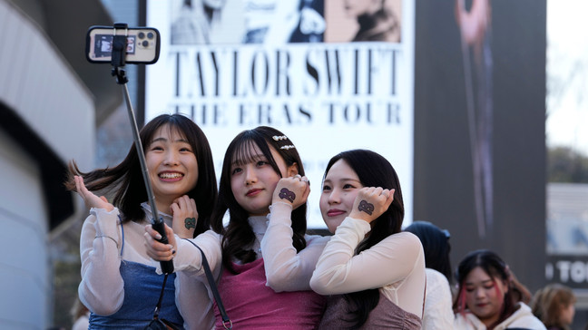 Women pose for a selfie before Taylor Swift's concert at Tokyo Dome in Tokyo, Saturday, Feb. 10, 2024. (AP Photo/Hiro Komae)