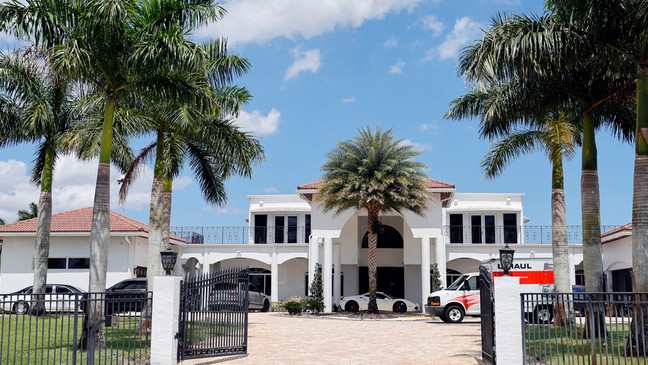 Sean Kingston's Southwest Ranches, Fla., home is shown during a raid by the Broward Sheriff's Office on Thursday, May 23, 2024. A SWAT team raided rapper Kingston's rented mansion on Thursday, and arrested his mother on fraud and theft charges that an attorney says stems partly from the installation of a massive TV at the home.  (Amy Beth Bennett/South Florida Sun-Sentinel via AP)