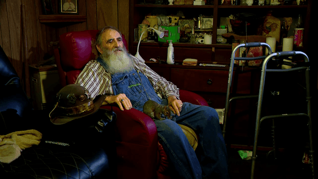 July 2022 - 50 years after the drama/thriller "Deliverance" was released, Haywood County resident Herbert ‘Cowboy’ Coward who played the ‘Toothless Man’ in the 1972 classic reflects on his career, sitting in his mountain home with his pet squirrel, "Cowgirl." (Photo credit: WLOS Staff)