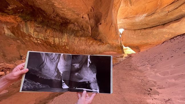 Eric Balken holds up a photo of what Cathedral in the Desert looked like before Glen Canyon Dam was built. It's easy to see how much sediment has piled up on the canyon floor. (Photo: Lincoln Graves, KUTV)