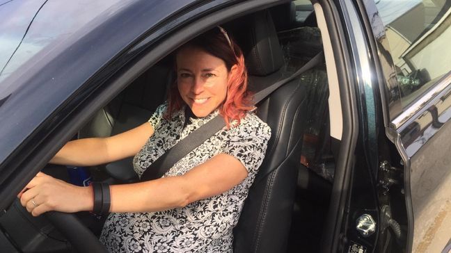 Sitting behind the wheel, Automotive Editor Jill Ciminillo shows how far back she has to sit to accommodate the larger belly. (Photo by Jon Erlich)