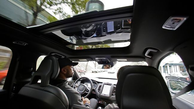 In this photo taken Tuesday, Dec. 13, 2016, Devin Greene sits in the front seat of an Uber driverless car during a test drive in San Francisco. Uber is bringing a small number of self-driving cars to its ride-hailing service in San Francisco - a move likely to both excite the city’s tech-savvy population and spark a conflict with California regulators. The Wednesday, Dec. 14, launch in Uber’s hometown expands a public pilot program the company started in Pittsburgh in September. (AP Photo/Eric Risberg)