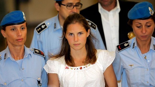 FILE - In this Tuesday Sept. 16, 2008 file photo, American murder suspect Amanda Knox, center, is escorted by Italian penitentiary police officers from Perugia's court after a hearing, central Italy.  Europe's human rights court has ordered Italy to pay Amanda Knox around 18,000 euros ($20,000) in financial damages for police failure to provide legal assistance and a translator during questioning following the Nov. 1, 2007 killing of her British roommate. The European Human Rights Court in Strasbourg, France, on Thursday ruled that Italy must pay Knox 10,400 euros damages plus 8,000 euros for costs and expenses. (AP Photo/Antonio Calanni, File)