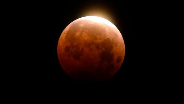 FILE - Light shines from a total lunar eclipse over Santa Monica Beach in Santa Monica, Calif., Wednesday, May 26, 2021. (AP Photo/Ringo H.W. Chiu, File)