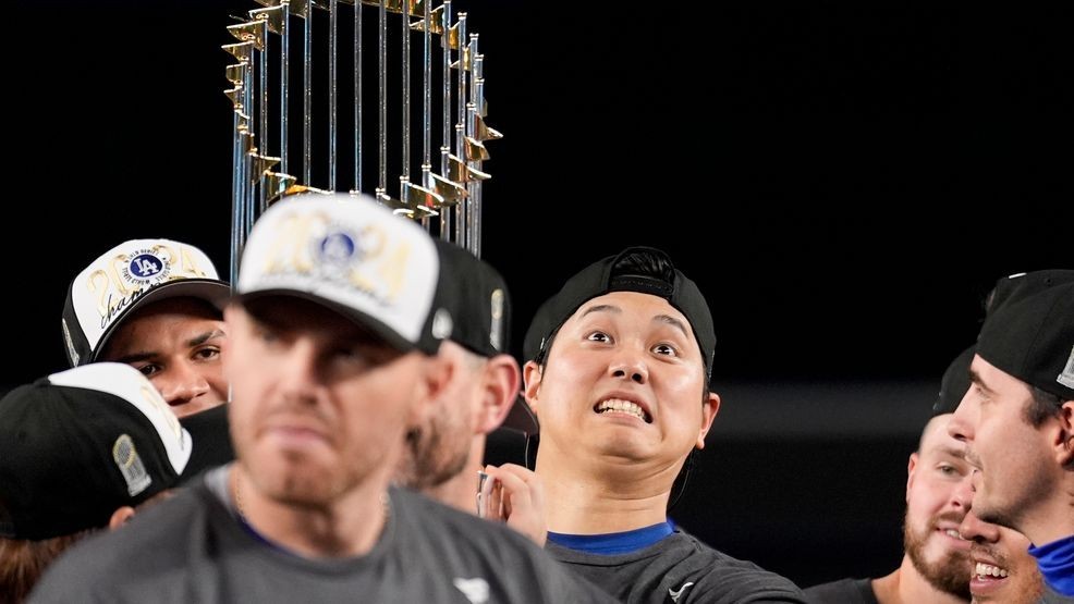 Los Angeles Dodgers' Shohei Ohtani celebrates with the trophy after their win against the New York Yankees in Game 5 to win the baseball World Series, Thursday, Oct. 31, 2024, in New York. (AP Photo/Ashley Landis)