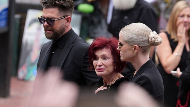 BIRMINGHAM, ENGLAND - JULY 30: Jack Osbourne, Sharon Osbourne, Kelly Osbourne and family members stop to view tributes to the late Ozzy Osbourne from fans at Black Sabbath Bench and Bridge as his funeral cortege travels through his home city of Birmingham on July 30, 2025 in Birmingham, England. The Black Sabbath frontman passed away on July 22nd at the age of 76. His death occurred just a little over two weeks after his final live performance at the 'Back to the Beginning' concert in his hometown of Birmingham. (Photo by Christopher Furlong/Getty Images)