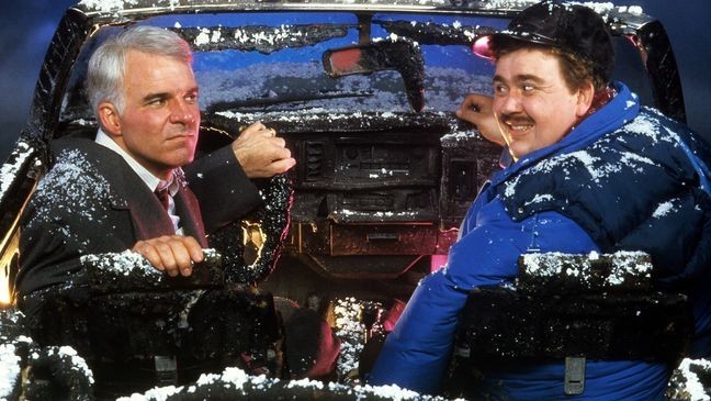 Steve Martin and John Candy sit in a destroyed car in a scene from the film 'Planes, Trains & Automobiles', 1987. (Photo by Paramount/Getty Images)