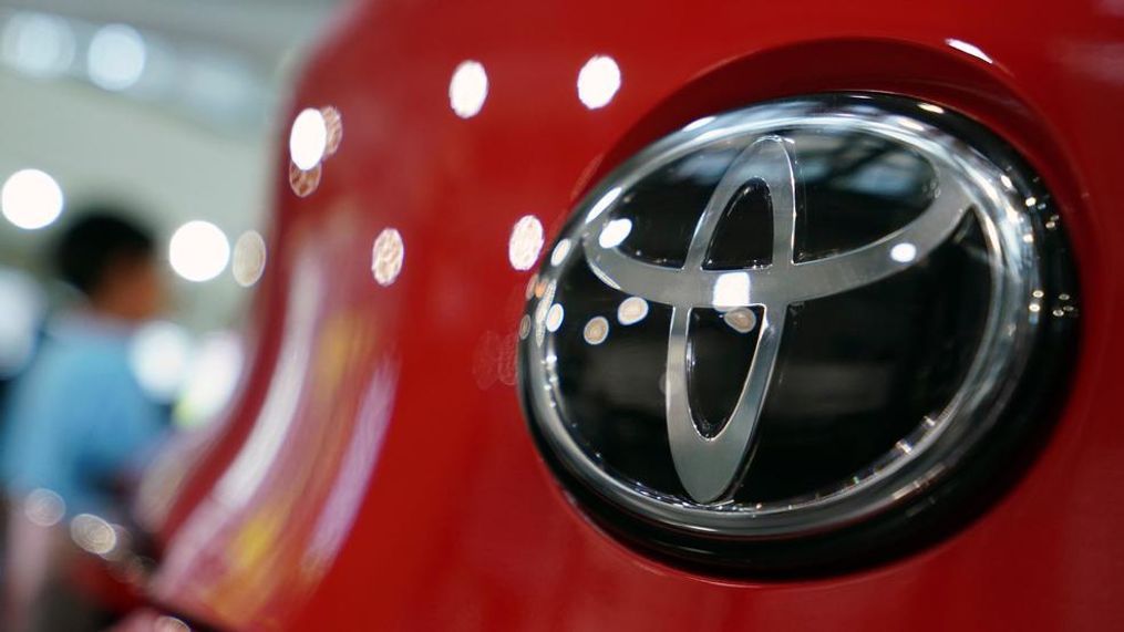 In this Aug. 2, 2019, file, photo, people walk by the logo of Toyota at a show room in Tokyo. Japan's top automaker Toyota has seen a 1% rise in July-September profit as vehicle sales grew around the world, according to Toyota's report on Thursday, Nov. 7, 2019. (AP Photo/Eugene Hoshiko, File)