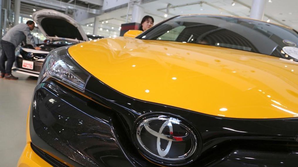 In this Nov. 13, 2017, photo, visitors take a look at Toyota cars at the automaker's showroom in Tokyo. Toyota Motor Corp. has raised its earnings forecast after reporting that its profit surged 28 percent in the last quarter on growing sales and cost cuts. The top Japanese automaker said Tuesday, Nov. 6, 2018, that its July-September profit was 585.1 billion yen ($5.2 billion), up from 458.3 billion yen the year before (AP Photo/Koji Sasahara)