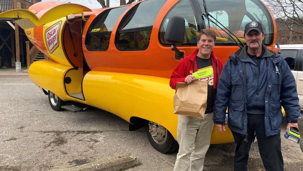 Alex Hale, a spokesperson for the Wienermobile, pauses for a photo with a member of Charleston Parking Enforcement. (Photo Courtesy of KraftHeinz){p}{/p}