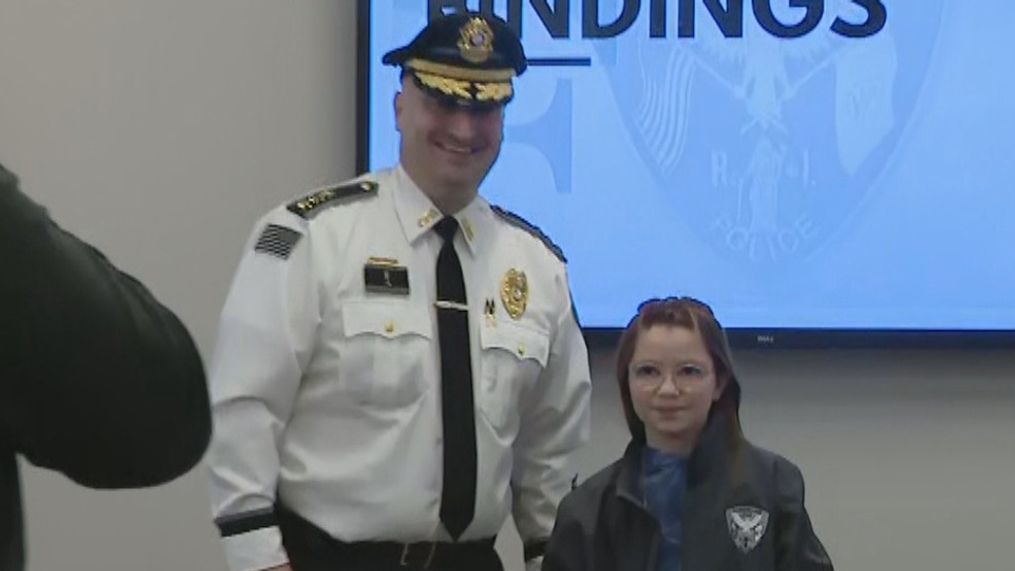 Cumberland Police Chief Matthew Benson stands with 10-year-old Scarlett Doumato at a news conference where he released the results of an investigation into the existence of Santa Claus. (WJAR)