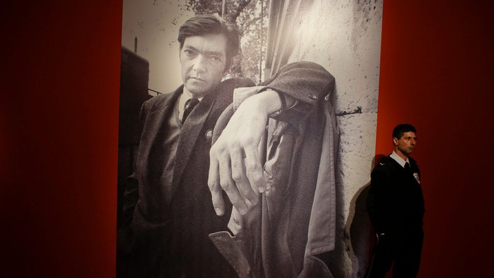 FILE - A security guard stands near a large photo of late writer Julio Cortazar at an exhibit marking the 100-year anniversary of his birth at the National Museum of Fine Arts in Buenos Aires, Argentina, Aug. 26, 2014. (AP Photo/Victor R. Caivano, File)