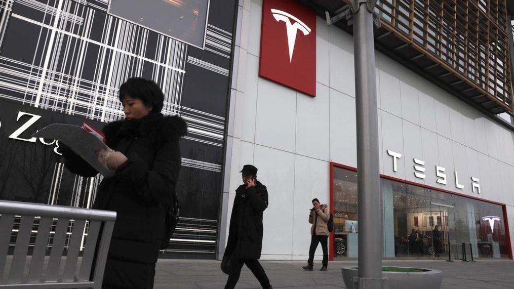 Residents walk past a Tesla store in Beijing, China, Monday, Jan. 7, 2019. Tesla Motors CEO Elon Musk said Monday on twitter that the automaker is breaking ground for a Shanghai factory and will start production of its Model 3 by the end of the year. (AP Photo/Ng Han Guan)