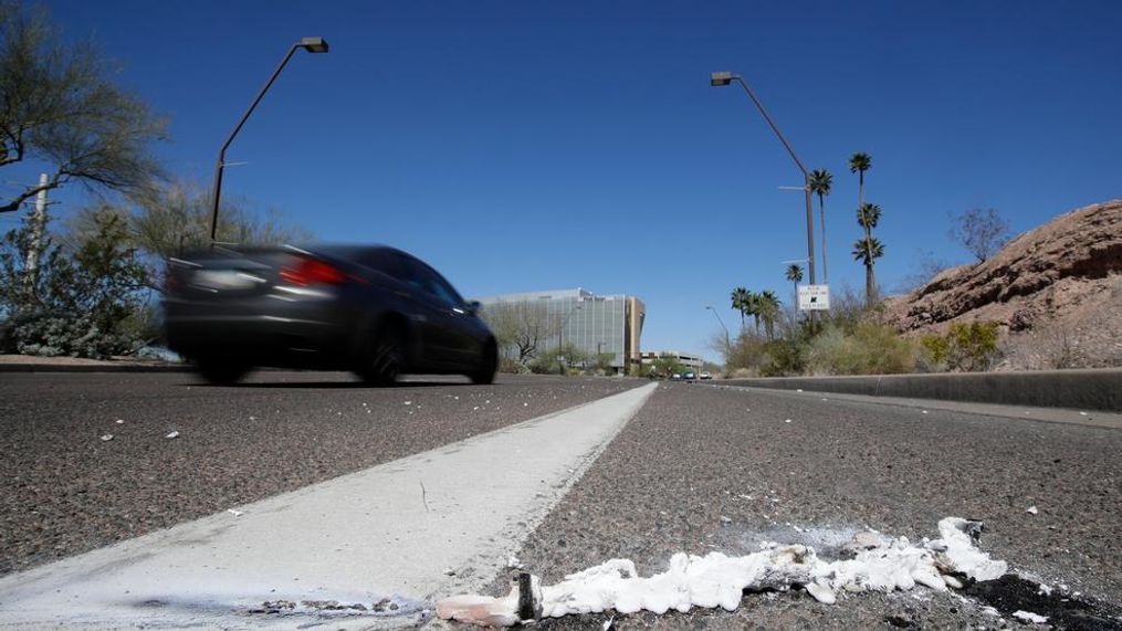 A vehicle goes by the scene of Sunday's fatality where a pedestrian was stuck by an Uber vehicle in autonomous mode, in Tempe, Ariz., Monday, March 19, 2018. A self-driving Uber SUV struck and killed the woman in suburban Phoenix in the first death involving a fully autonomous test vehicle. (AP Photo/Chris Carlson)