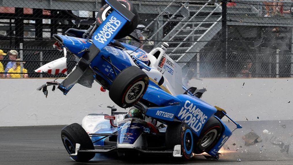 The car driven by Scott Dixon, of New Zealand, goes over the top of Jay Howard, of England, in the first turn during the running of the Indianapolis 500 auto race at Indianapolis Motor Speedway, Sunday, May 28, 2017, in Indianapolis. (AP Photo/Marty Seppala)