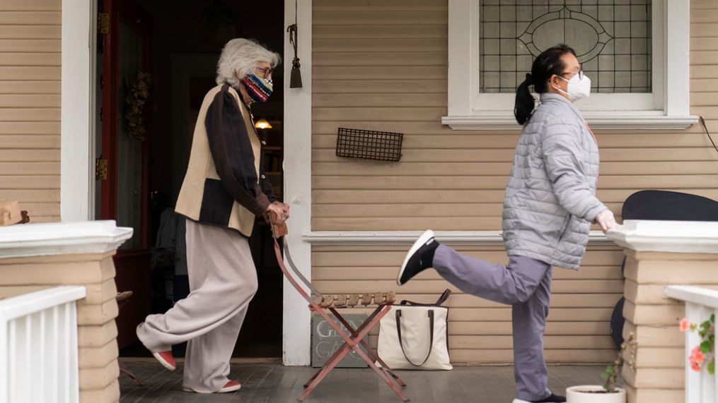 FILE - In this May 17, 2021 file photo, designer Gere Kavanaugh, left, wears a face mask of her design, as she exercises with Silver Age Home Health licensed vocational nurse Daisy Cabaluna during a weekly outdoors session at her home in the Echo Park neighborhood of Los Angeles. (AP Photo/Damian Dovarganes, File)