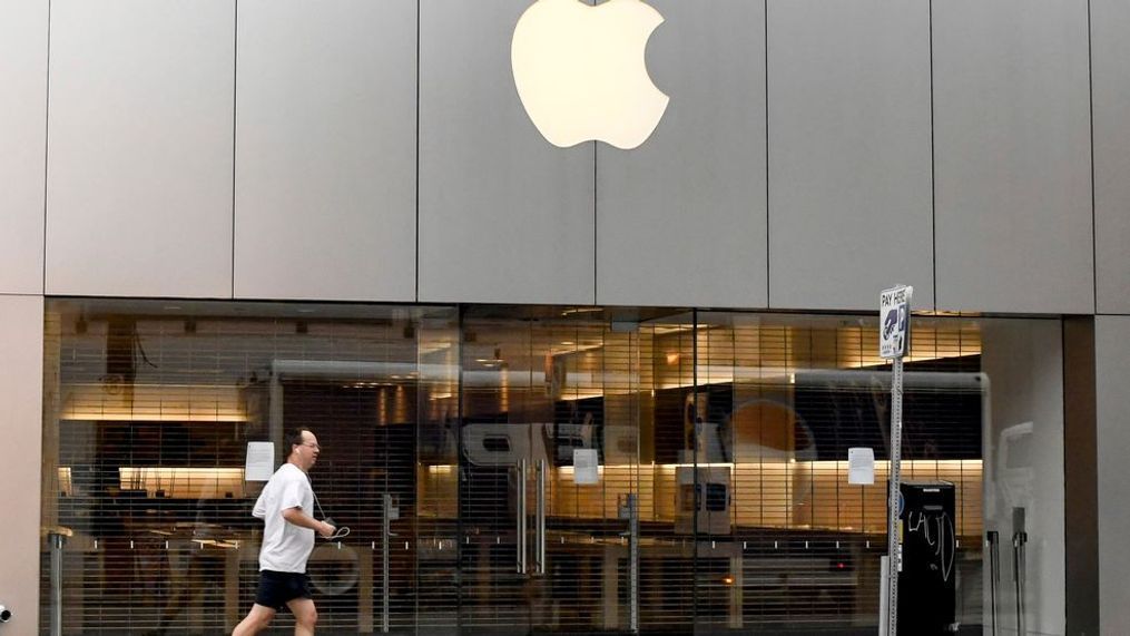 A jogger runs past an Apple Store closed due to the COVID-19 pandemic, Tuesday, April 7, 2020, in the business district of Shadyside in Pittsburgh. (Darrell Sapp/Pittsburgh Post-Gazette via AP)