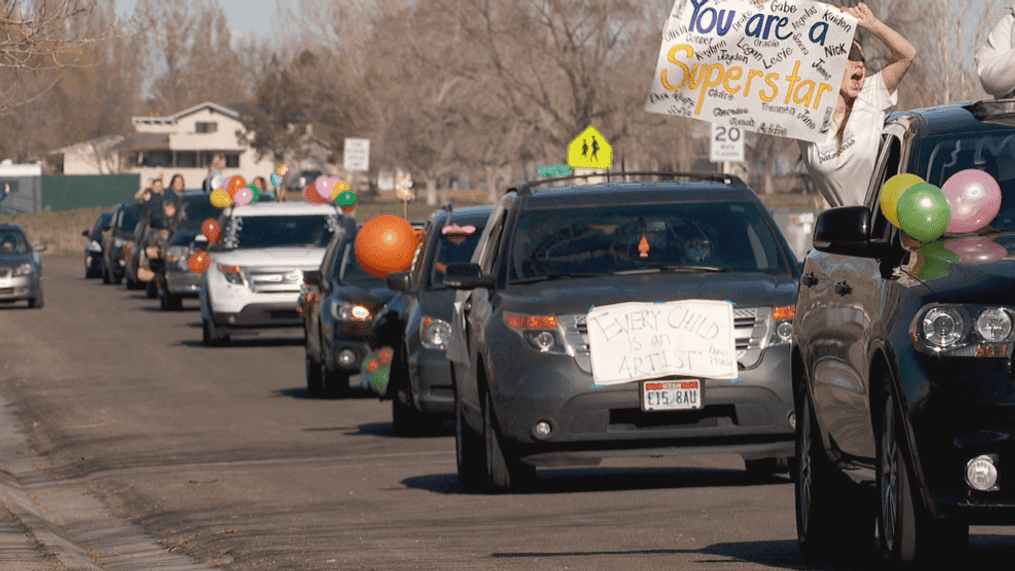 Kids line streets for teacher parade. (KUTV)