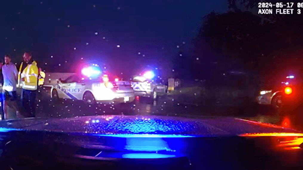 Dashcam footage released by police shows Scottie Scheffler in handcuffs being escorted by two officers at the scene. (Louisville Metro Police)