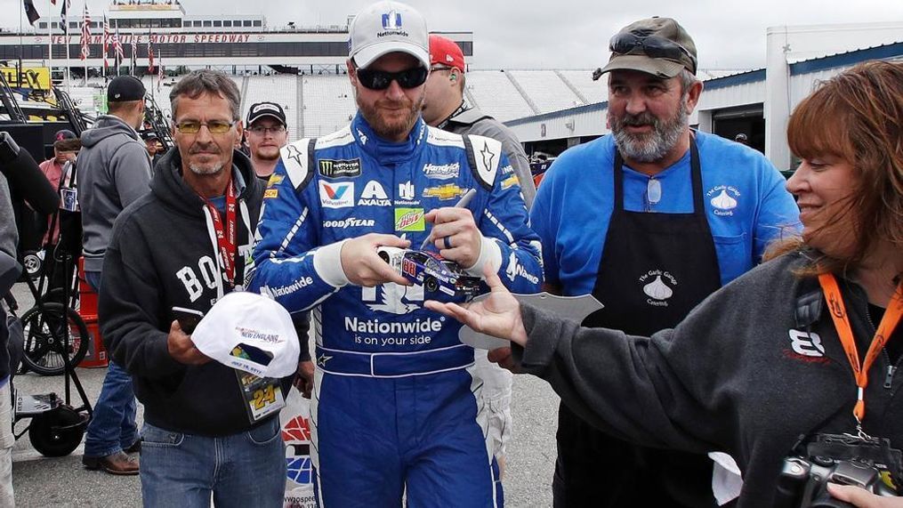 Driver Dale Earnhardt Jr. signs autographs for fans as he walks through the garage area after a NASCAR auto racing practice at the New Hampshire Motor Speedway in Loudon, N.H., Friday, July 14, 2017. (AP Photo/Charles Krupa)