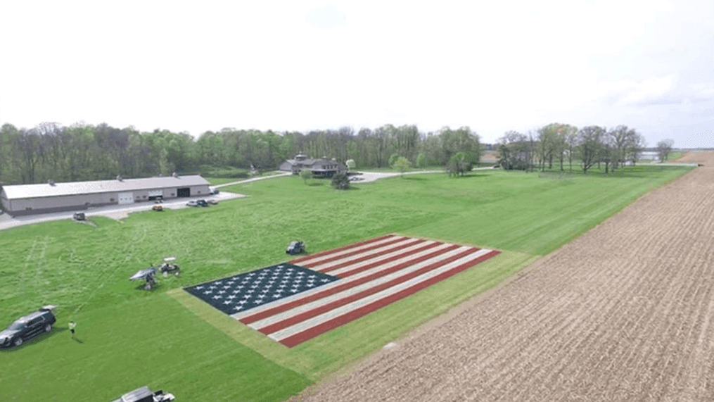 Justin Riggins recruited his family and friends to help paint a 10,000 square foot version of "Old Glory" in the grass on his property. (CNN Newsource)