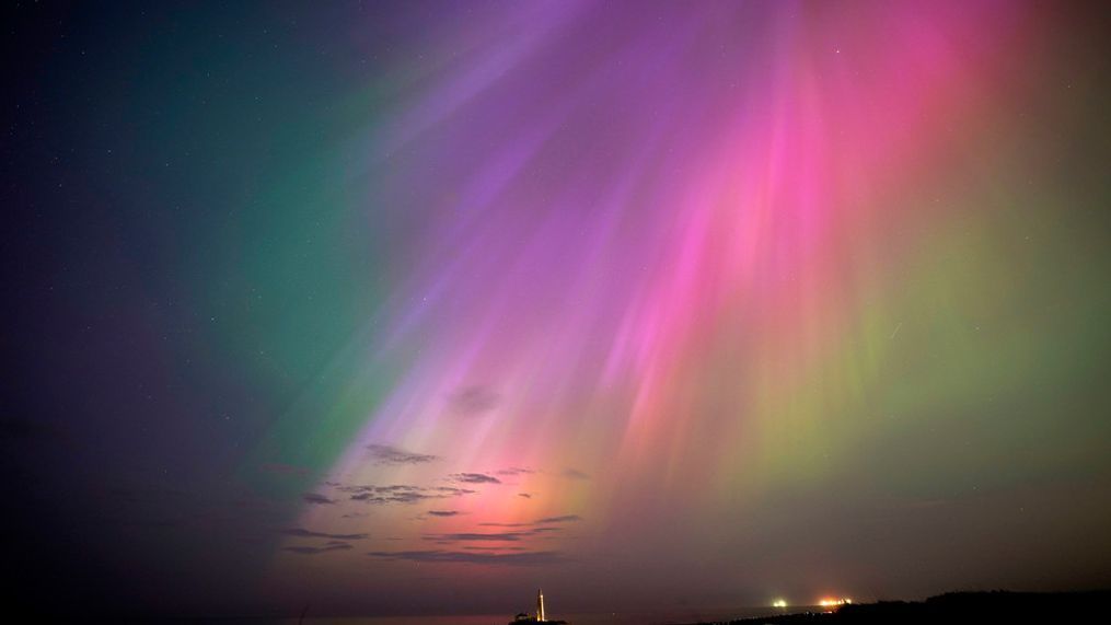 The aurora borealis, also known as the northern lights, glow on the horizon at St. Mary's Lighthouse in Whitley Bay on the North East coast, England, Friday, May 10, 2024. (Owen Humphreys/PA via AP)