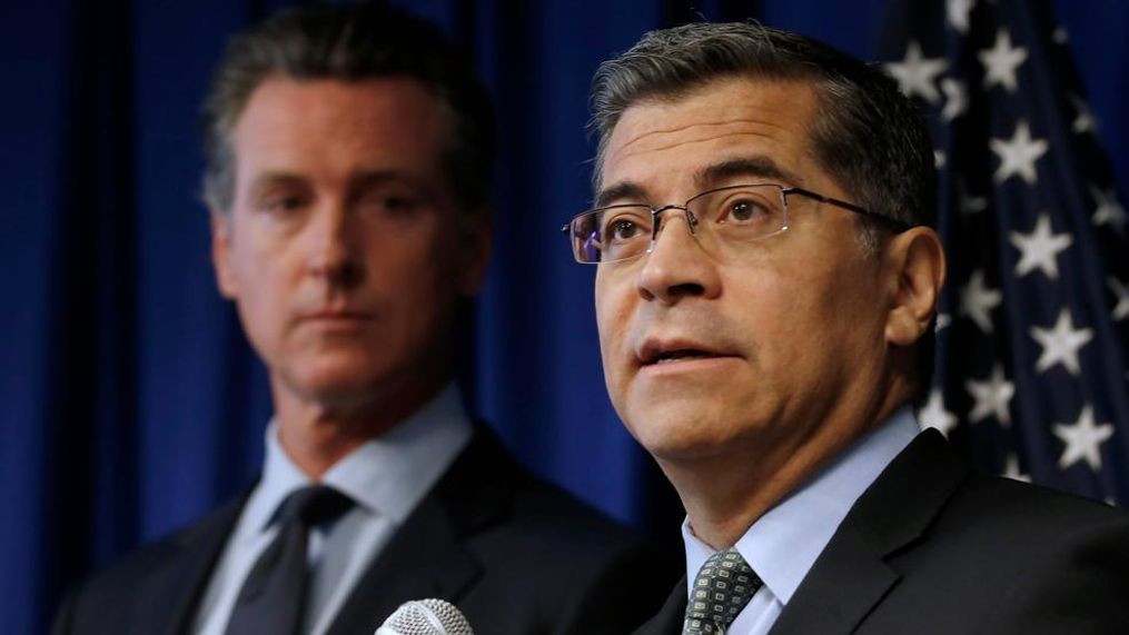 FILE- California Attorney General Xavier Becerra, right, flanked by Gov. Gavin Newsom, discusses the Trump administration's pledge to revoke California's authority to set vehicle emissions standards that are different than the federal standards, during a news conference in Sacramento, Calif., Wednesday, Sept. 18, 2019. (AP Photo/Rich Pedroncelli)