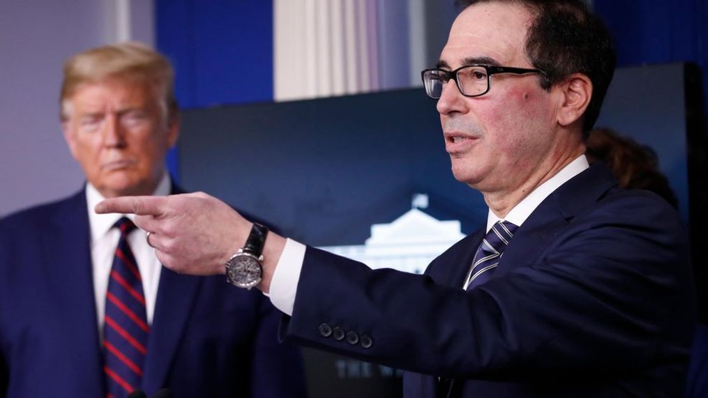 President Donald Trump listens as Treasury Secretary Steven Mnuchin speaks about the coronavirus in the James Brady Press Briefing Room of the White House, Thursday, April 2, 2020, in Washington. (AP Photo/Alex Brandon)