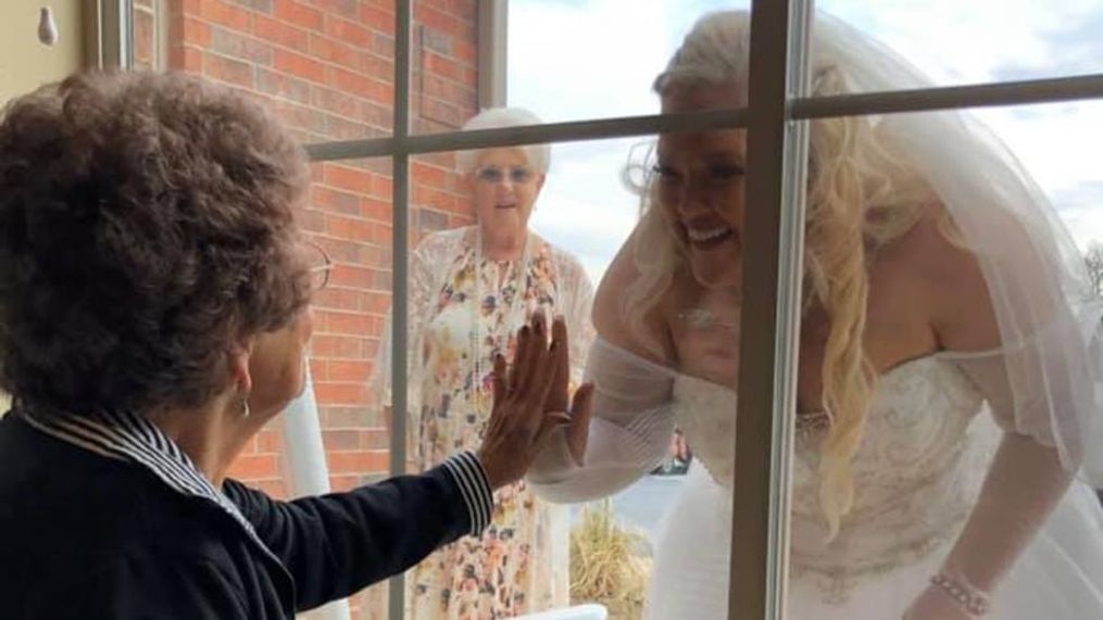 Woman visits grandma through window of assisted living home in her wedding gown (KTUL)