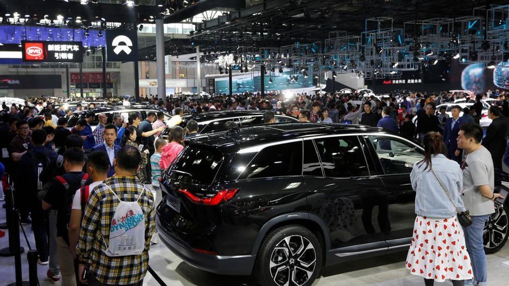 FILE - In this April 29, 2018, file photo, visitors watch an electric-powered SUV manufactured by Chinese automaker NIO during the China Auto Show in Beijing. The 2019 Shanghai auto show highlights the global industry's race to transform electric cars into a profitable product Chinese drivers want to buy as Beijing winds down multibillion-dollar subsidies that made this country the biggest market for the technology. (AP Photo/Andy Wong, File)