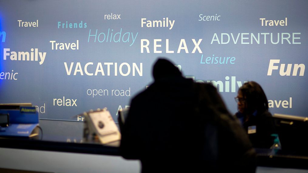 In this file photo, a travel-themed backdrop stands behind a rental car check-in counter as a customer rents a car at Hartsfield–Jackson Atlanta International Airport, in Atlanta. Your credit card may provide important protections if you get in an accident in a rental car. Find out what it covers before the insurance hard sell at the rental counter. (AP Photo/David Goldman, File){p}{/p}