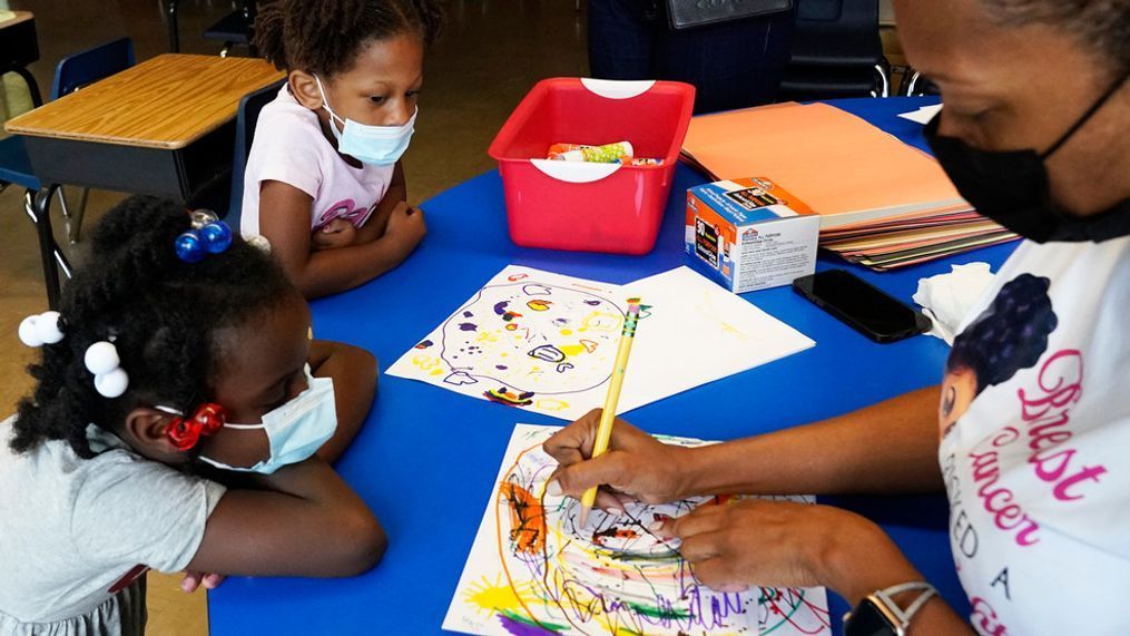 Laiah Collins, 4, top left, and Charisma Edwards, 5, work with Davetra Richardson (STLS), right, in a classroom at Chalmers Elementary school in Chicago, Wednesday, July 13, 2022. (AP Photo/Nam Y. Huh)