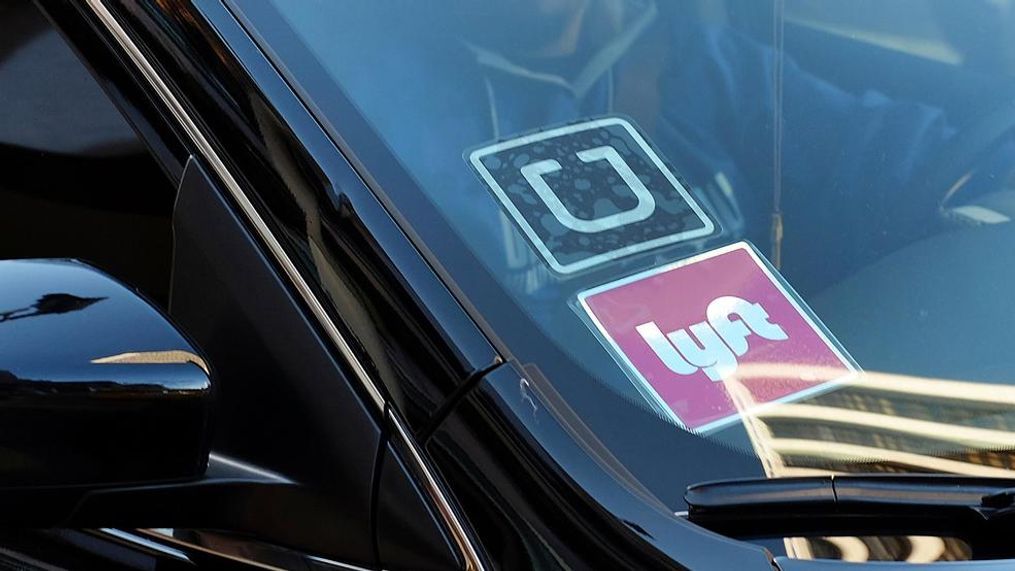 FILE - In this Tuesday, Jan. 12, 2016, file photo, a driver displaying Lyft and Uber stickers on his front windshield drops off a customer in downtown Los Angeles. Driving for Uber or Lyft or renting out your house on Airbnb may sound like a good way to make some extra cash, but don’t forget that you likely need to pay federal taxes on what you earned. And since the IRS considers on-demand workers to be self-employed, it also helps to keep track of expenses that can help reduce your tax bill. (AP Photo/Richard Vogel, File)