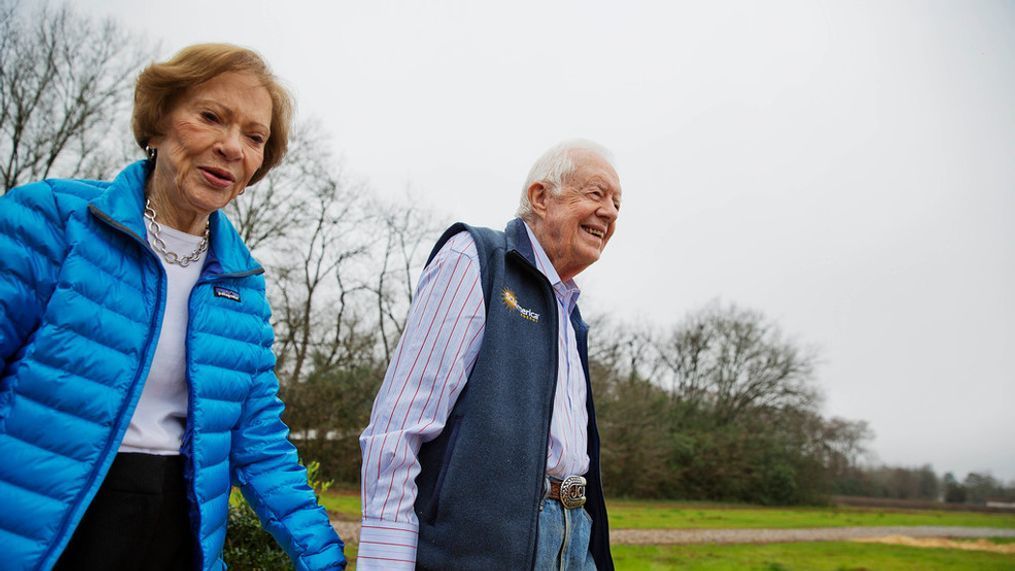 FILE - In this Feb. 8, 2017, photo, former President Jimmy Carter, right, and his wife Rosalynn arrive for a ribbon cutting ceremony for a solar panel project on farmland he owns in their hometown of Plains, Ga. (AP Photo/David Goldman, File)