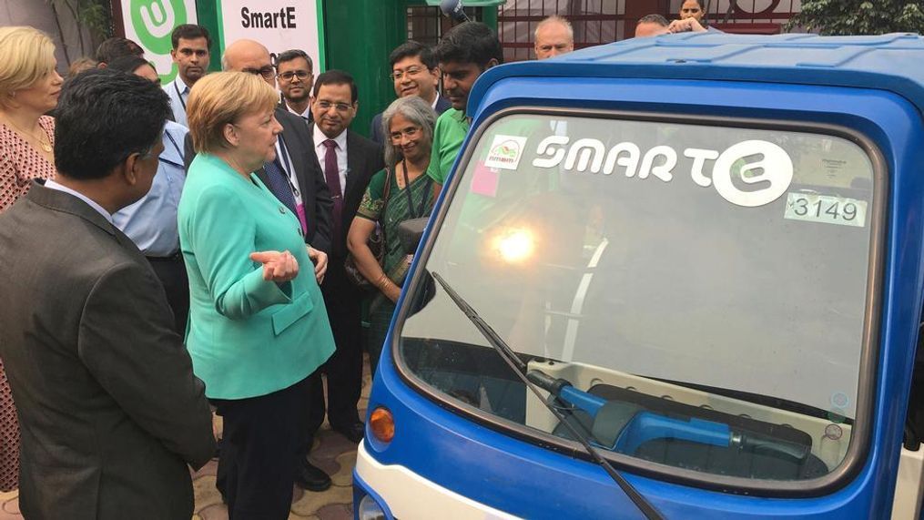 German Chancellor Angela Merkel speaks with a driver of an electric vehicle at a metro station in New Delhi, India, Saturday, Nov. 2, 2019. India and Germany agreed on Friday to enhance cooperation in tackling climate change, cybersecurity, skill development, artificial intelligence, energy security, civil aviation and defense production. The two countries signed several agreements, with Prime Minister Narendra Modi saying India is eager to benefit from Germany's expertise. (AP Photo/Shonal Ganguly)