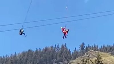Image for story: VIDEO: Swiss paraglider rescued from a mountain power line 