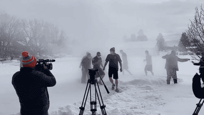 Image for story: Police officers create own version of polar bear plunge with firehose and snow angels