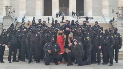 Image for story: John Legend, Chrissy Teigen take viral photo with Virginia police