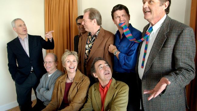 FILE - In this March 21, 2003, file photo, the cast of the film "The Mighty Wind," standing from left, Christopher Guest, Eugene Levy, Michael McKean, John Michael Higgins, Fred Willard, and, seated, Bob Balaban, Jane Lynch, and Harry Shearer, amuse themselves during a photo shoot in Beverly Hills, Calif. (AP Photo/Kevork Djansezian, File)