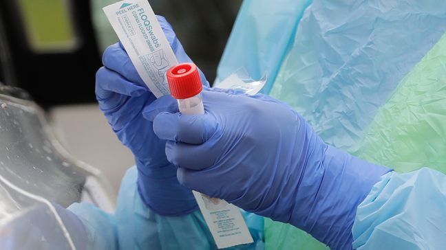 FILE - In this April 2, 2020, file photo a nurse holds a vial and a swab at a drive-up coronavirus testing station at a hospital in Seattle.{&nbsp;} (AP Photo/Ted S. Warren, File)