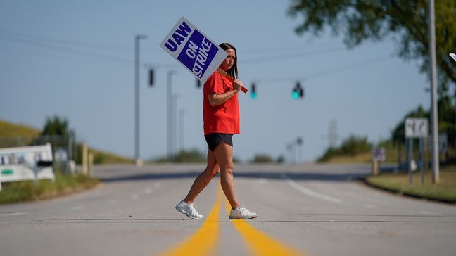 Temporary plant worker Shanuel Merevith, of Edmonson County, Ky., carries a sign and walks the picket line outside the as General Motors assembly plant in Bowling Green, Ky, Monday, Sept. 16, 2019. Thousands of members of the United Auto Workers walked off General Motors factory floors or set up picket lines early Monday as contract talks with the company deteriorated into a strike. (AP Photo/Bryan Woolston)