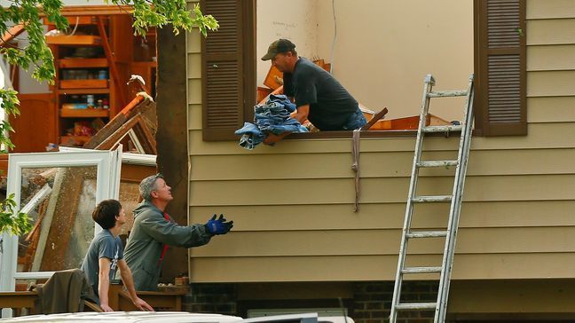 A man passes off a bundle of blue jeans as he tries to collect clothing for his family after being hit by a tornado on Tuesday, May 28, 2019, in a neighborhood south of Lawrence, Kan., near US-59 highway and N. 1000 Road. The past couple of weeks have seen unusually high tornado activity in the U.S., with no immediate end to the pattern in sight. (Chris Neal/The Topeka Capital-Journal via AP)