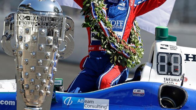 Indianapolis 500 champion Takuma Sato, of Japan, poses with the Borg-Warner Trophy during the traditional winners photo session on the start/finish line at the Indianapolis Motor Speedway in Indianapolis, Monday, May 29, 2017. (AP Photo/Michael Conroy)