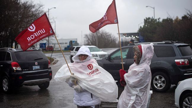 Members of Unifor, the union representing the workers of Oshawa's General Motors assembly plant, stand near the entrance to the plant in Oshawa, Ontario, Monday, Nov. 26, 2018. General Motors will lay off thousands of factory and white-collar workers in North America and put five plants up for possible closure as it restructures to cut costs and focus more on autonomous and electric vehicles. General Motors is closing the Oshawa plant. (Eduardo Lima/The Canadian Press via AP)