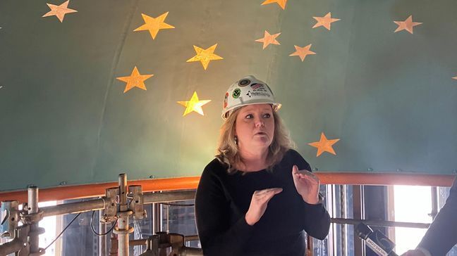 Barb Thumudo, assistant director of capitol facilities, provides media members with a tour of restorations of the Michigan State Capitol Building's rotunda on April 4, 2024. In the center of the rotunda's oculus, or "eye," a night sky is depicted. (James Prince/WWMT)