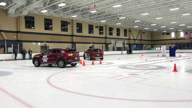 Two all-wheel-drive Kia Sportages during a winter tire driving experiment. The car on the right has winter tires and can turn at 90 degrees going 10 mph, while the car on the left with all-season tires hits the cones. (Sinclair Broadcast Group / Jill Ciminillo){p}{/p}