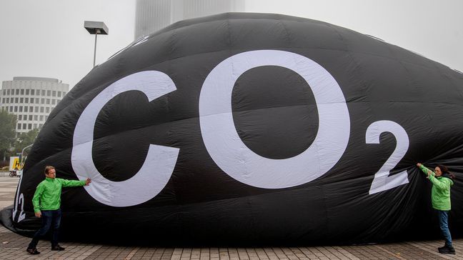 Activists of the environment protection organization 'Greenpeace'  pump up a giant ballon to protest against climate-damaging cars displayed at the IAA Auto Show in Frankfurt, Germany, Tuesday, Sept. 10, 2019. (AP Photo/Michael Probst)