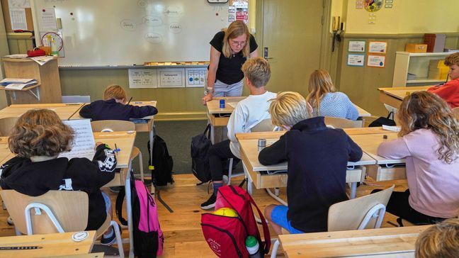 A teacher helps students practice their handwriting at the Djurgardsskolan elementary school in Stockholm, Sweden, Thursday, Aug. 31, 2023. (AP Photo/David Keyton)