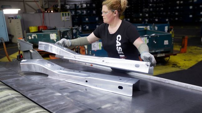 In this April 30, 2015, file photo, United Auto Workers line worker Crystal McIntyre unloads parts from a stamping machine at the General Motors Pontiac Metal Center in Pontiac, Mich. If President Donald Trump delivers on threats to slap 25 percent tariffs on imported automobiles and parts, experts say it will cut auto sales and cost jobs in the U.S., Canada and Mexico. (AP Photo/Carlos Osorio, File)