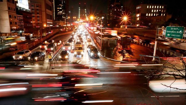 FILE- In this Jan. 11, 2018, file photo, cars pass the Queensboro Bridge in New York. The Trump administration is citing safety to justify freezing gas mileage requirements. A draft of a regulation prepared this summer would freeze an Obama-era program to improve fuel efficiency and cut pollution. (AP Photo/Frank Franklin II, File)